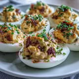 Deviled eggs topped with paprika and fresh chives, a tangy, velvety appetizer perfect for potlucks and holiday parties.  
