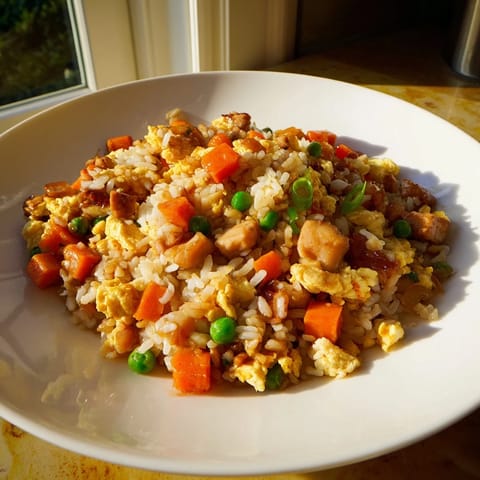 Vibrant Chicken Fried Rice: a steaming bowl featuring tender chicken, veggies, and savory sauce.