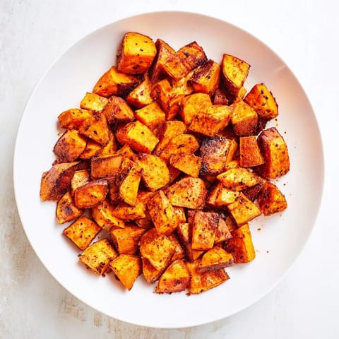Tender, caramelized roasted sweet potatoes, ready to be served, smell wonderfully spiced from the oven.