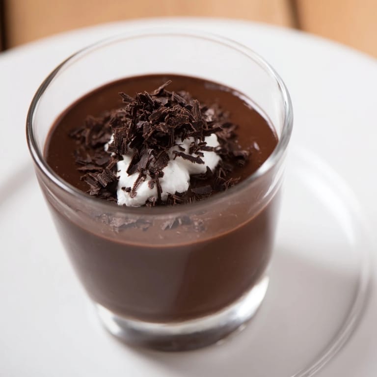 Silky smooth chocolate pudding, topped with whipped cream, perfect for a decadent treat.