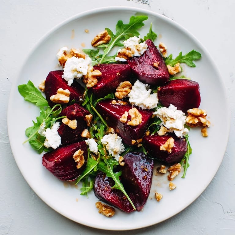Serving suggestion for roasted beet goat cheese salad garnished with fresh chives, ideal for a vegetarian dinner side.