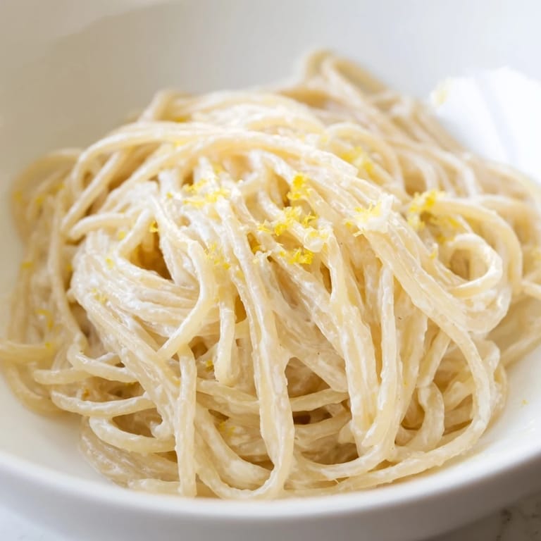 A bowl of Lemon Ricotta Pasta, garnished with basil, served on a rustic table for a light lunch.