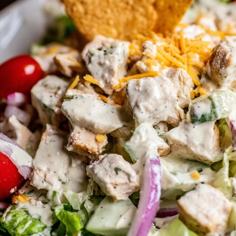Ready-to-serve Jalapeño Ranch Chicken Salad in a white bowl, garnished with tortilla strips and a lime wedge, perfect for an easy summer lunch.