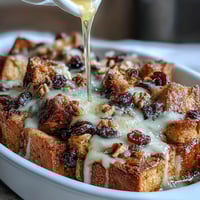 Warm, gooey Capirotada with cinnamon, piloncillo, and raisins—a Mexican bread pudding topped with melty cheese and crunchy nuts.