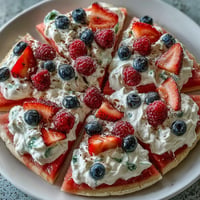 Festive 4th of July Watermelon Pizza topped with colorful berries and fluffy cream.